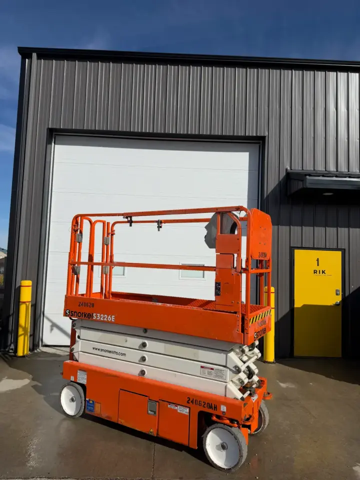 Orange Snorkel electric scissor lift from the side, platform lowered